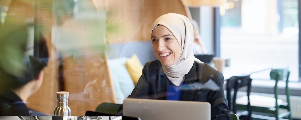 Två kvinnor skrattar på ett café